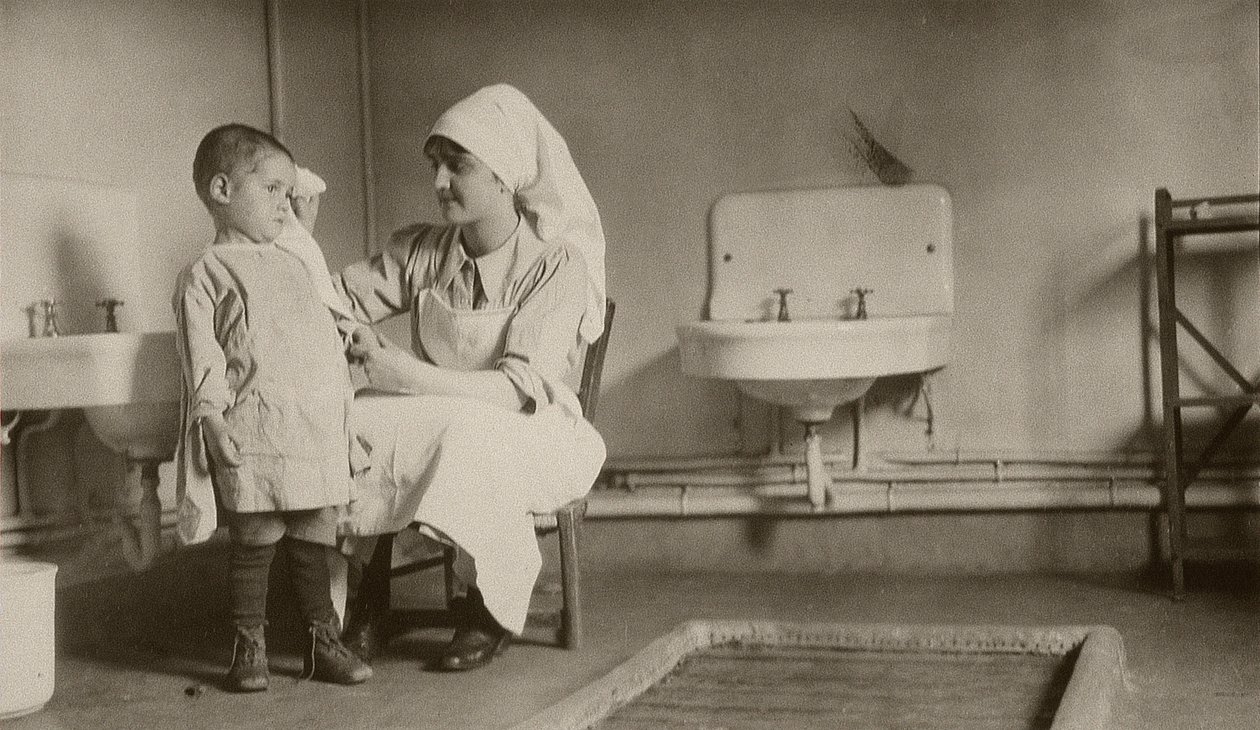 ممرضة ترعى طفلاً مريضًا في مستعمرات Passay و Saint-Quentin للاجئين والأيتام ، 1919 بواسطة مصور أمريكي