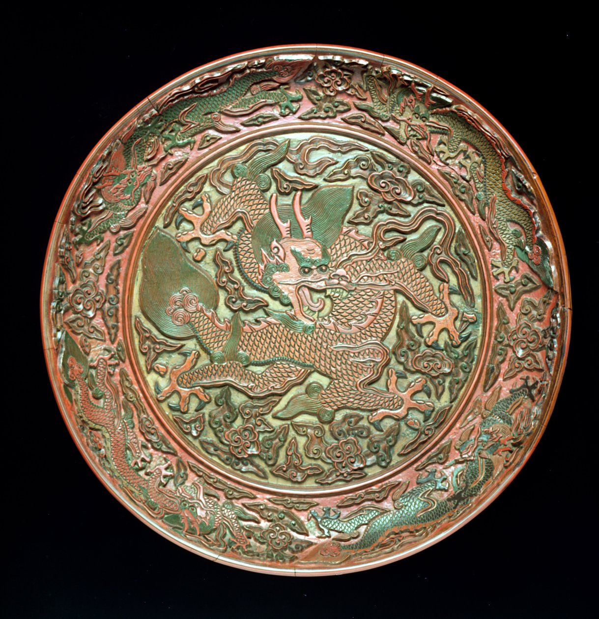 طبق دائري مُزين بتسعة تنانين ، أسرة مينغ 1403-1644 ، فترة جيانجينج 1522-66 (ورنيش منحوت) بواسطة المدرسة الصينية