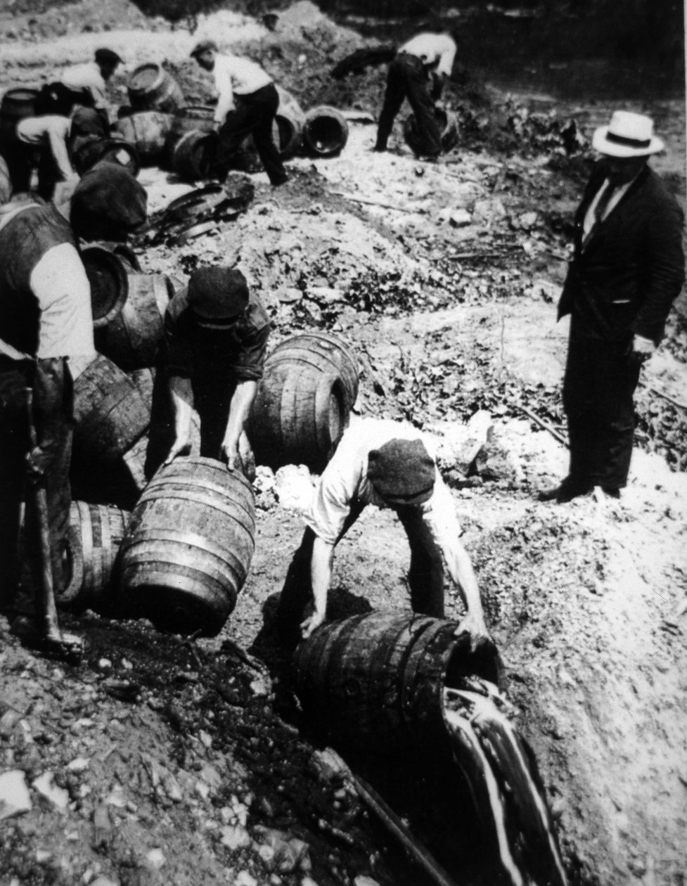 A US Federal Agent oversees the destruction of beer kegs during the American Prohibition era (1920-33) (b/w photo) بواسطة مصور أمريكي