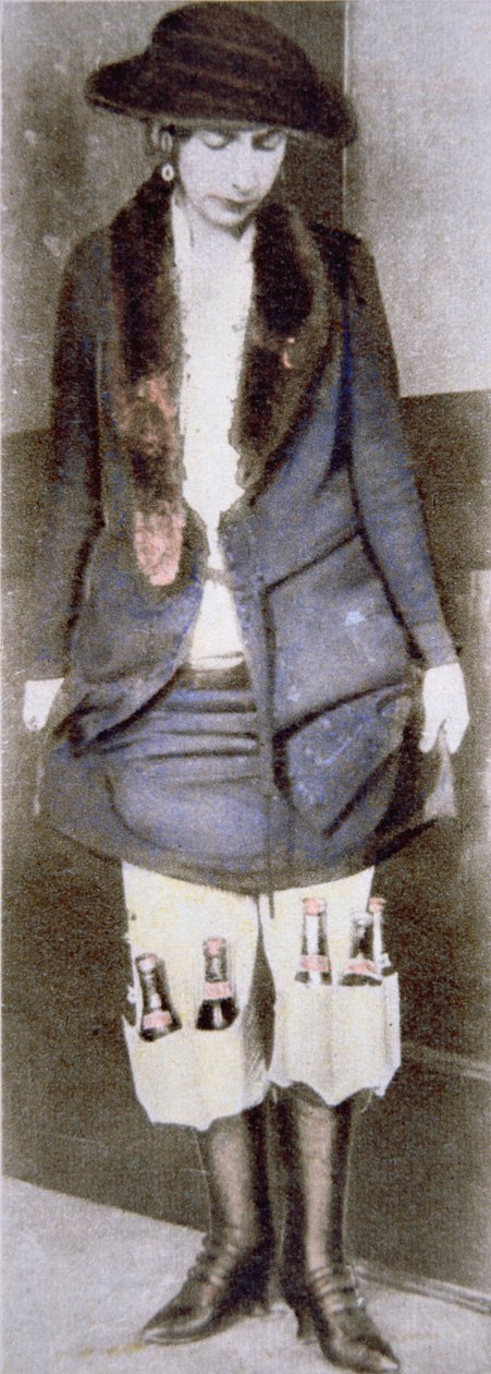 A woman hiding illegal bottles of beer under her skirt in special underwear pockets during the American Prohibition (1920-33) (coloured photo) بواسطة مصور أمريكي
