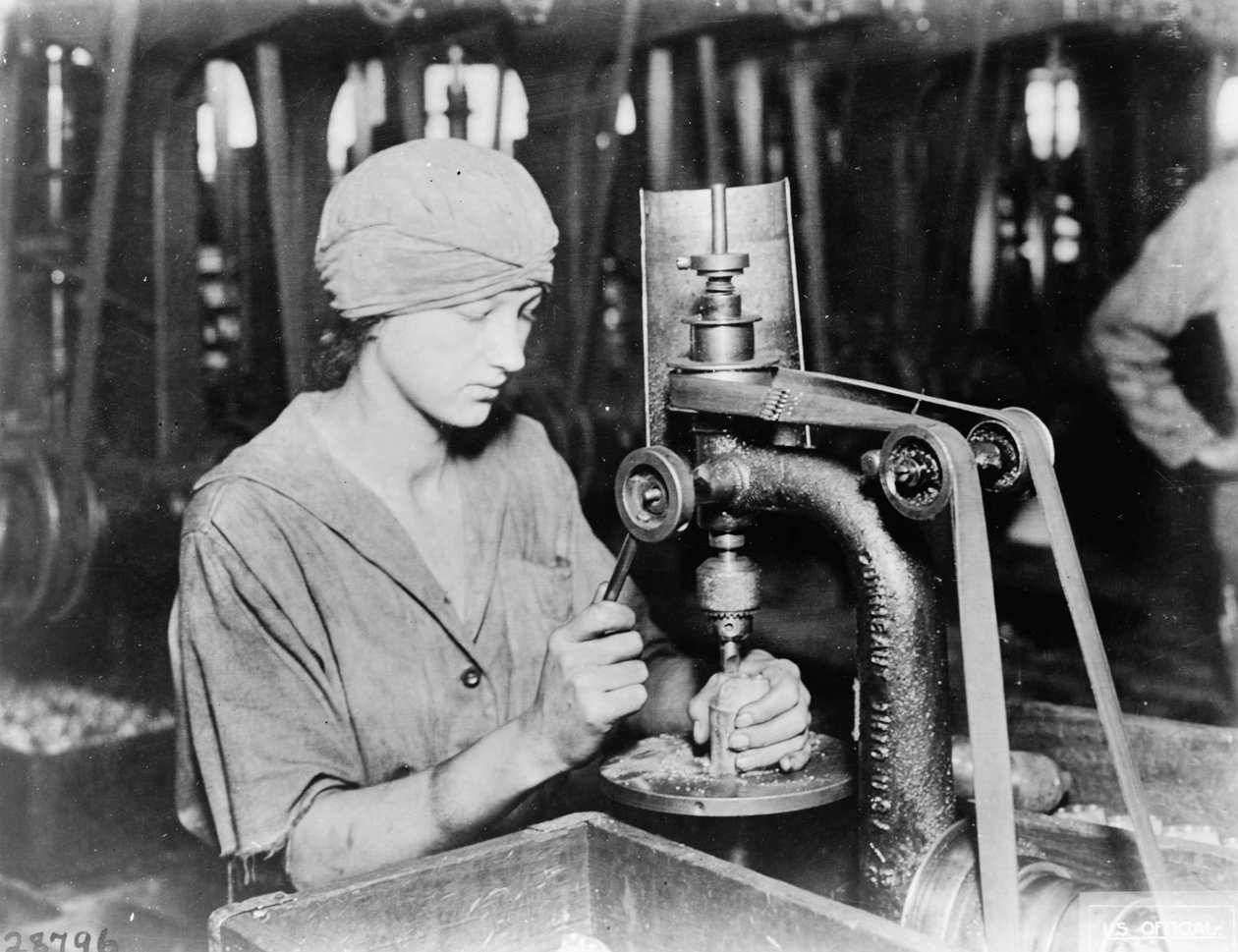 امرأة ثقب أنبوب مفجر غاطس وفتحة تعبئة في قنبلة يدوية في Westinghouse Electric & Mfg. Co. ، شرق بيتسبرغ ، بنسلفانيا ، خلال الحرب العالمية الأولى ، 1914-1918 بواسطة مصور أمريكي