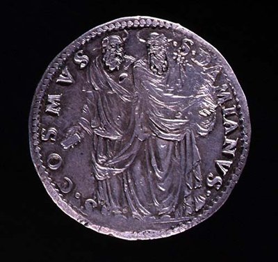 عكس عملة فضية تصور SS Cosimo و Damien واقفين ويحدقان في بعضهما البعض. النقش: S. COSMVS S. DAMIANVS ، ضُرِع 1532-1537 (للوجوه انظر 108641) بواسطة بنفينوتو تشيليني