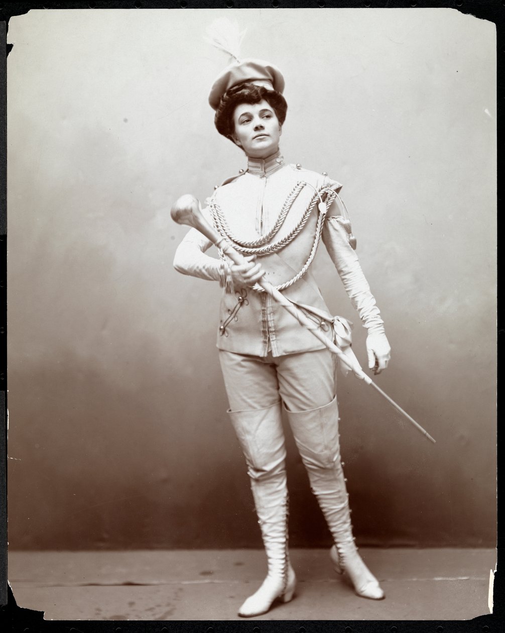 امرأة تعمل على تشكيل زي فرقة ، تحمل عصا ، c.1898 (طباعة الجيلاتين الفضي) بواسطة شركة بايرون