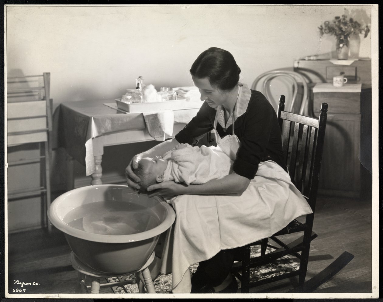 امرأة تغسل رأس طفل في جمعية مركز الأمومة في 211 East 57th Street ، نيويورك ، 1934 (طباعة الجيلاتين الفضي) بواسطة شركة بايرون