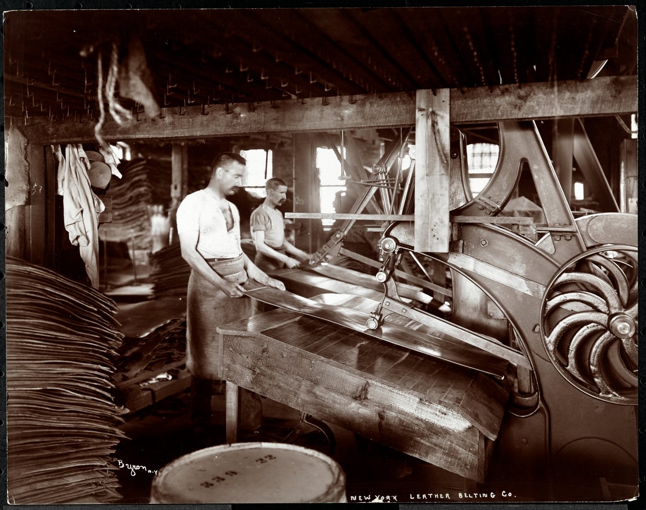 منظر داخلي لرجلين يعملان بالجلد والمعدات الثقيلة في شركة New York Leather Belting Co. ، نيويورك ، 1905 (طباعة الجيلاتين الفضي) بواسطة شركة بايرون