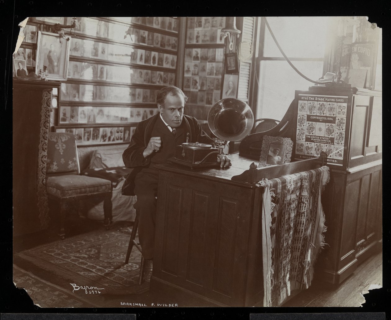 مارشال ب.ويلدر يستمع إلى رقم قياسي على victrola في مكتبه ، 1898-99 (طباعة الجيلاتين الفضي) بواسطة شركة بايرون