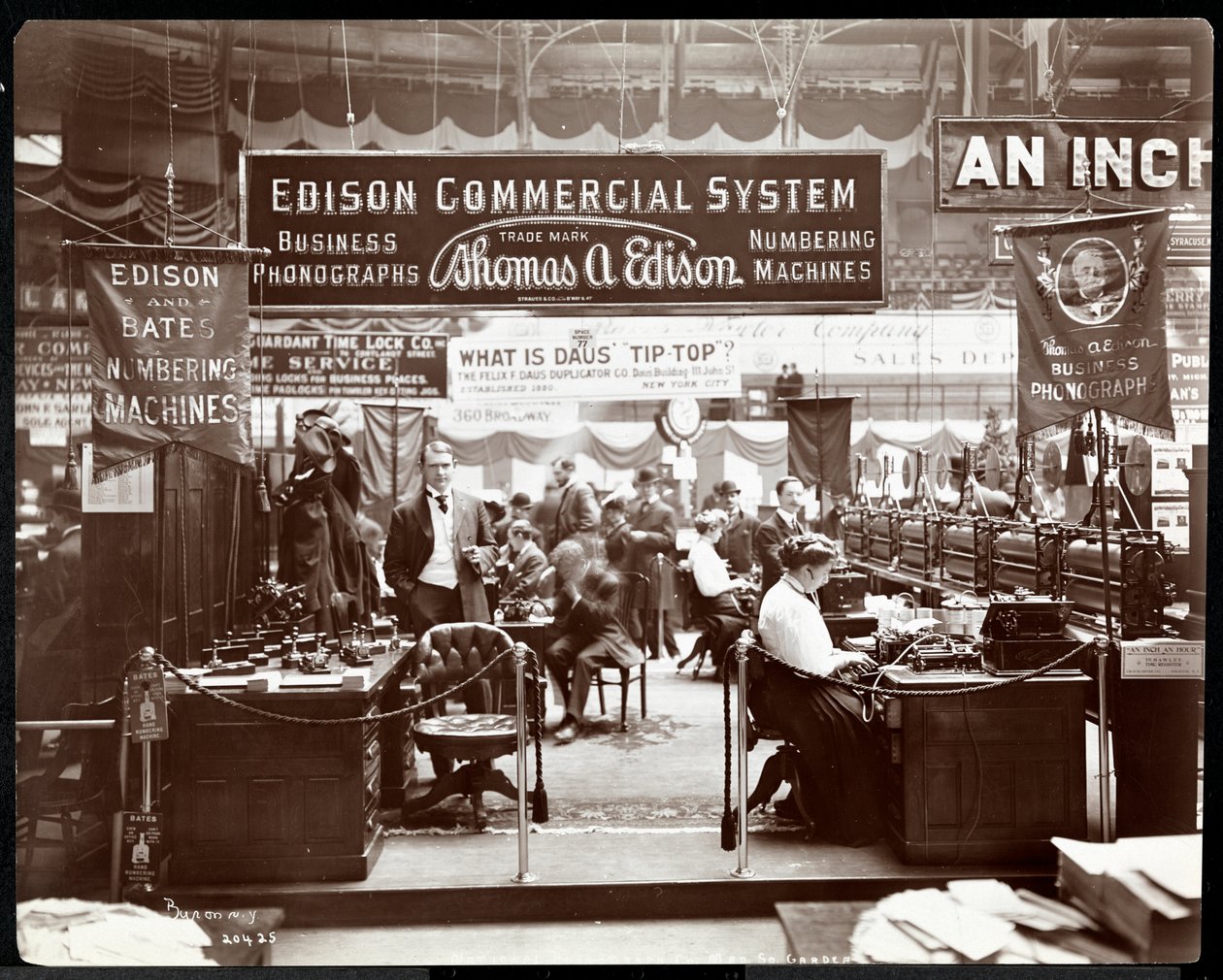مشهد من كشك شركة Edison Co. لمعدات المكاتب في معرض تجاري في Madison Square Garden ، نيويورك ، 1906 (طباعة الجيلاتين الفضي) بواسطة شركة بايرون