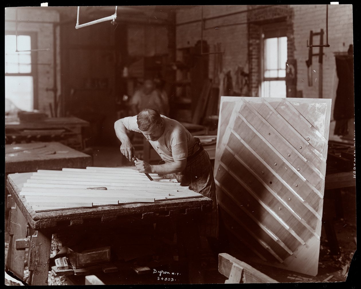 رجل يعمل في مصنع Hardman ، Peck und Co. Piano ، نيويورك ، 1907 (طباعة الجيلاتين الفضي) بواسطة شركة بايرون