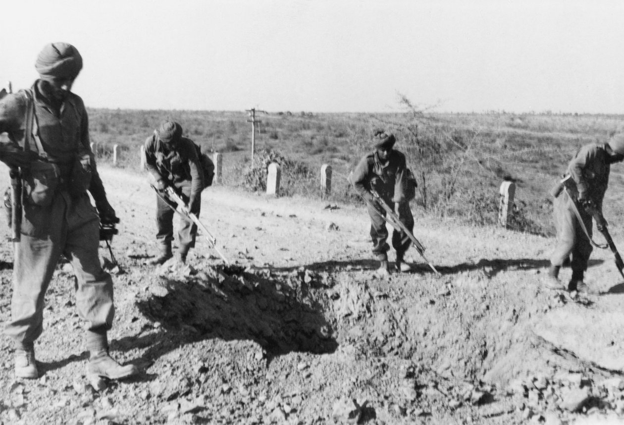 صوامع الهنود يبحثون عن مناجم على طول طريق ترابي ، 1941 بواسطة مصور انجليزى