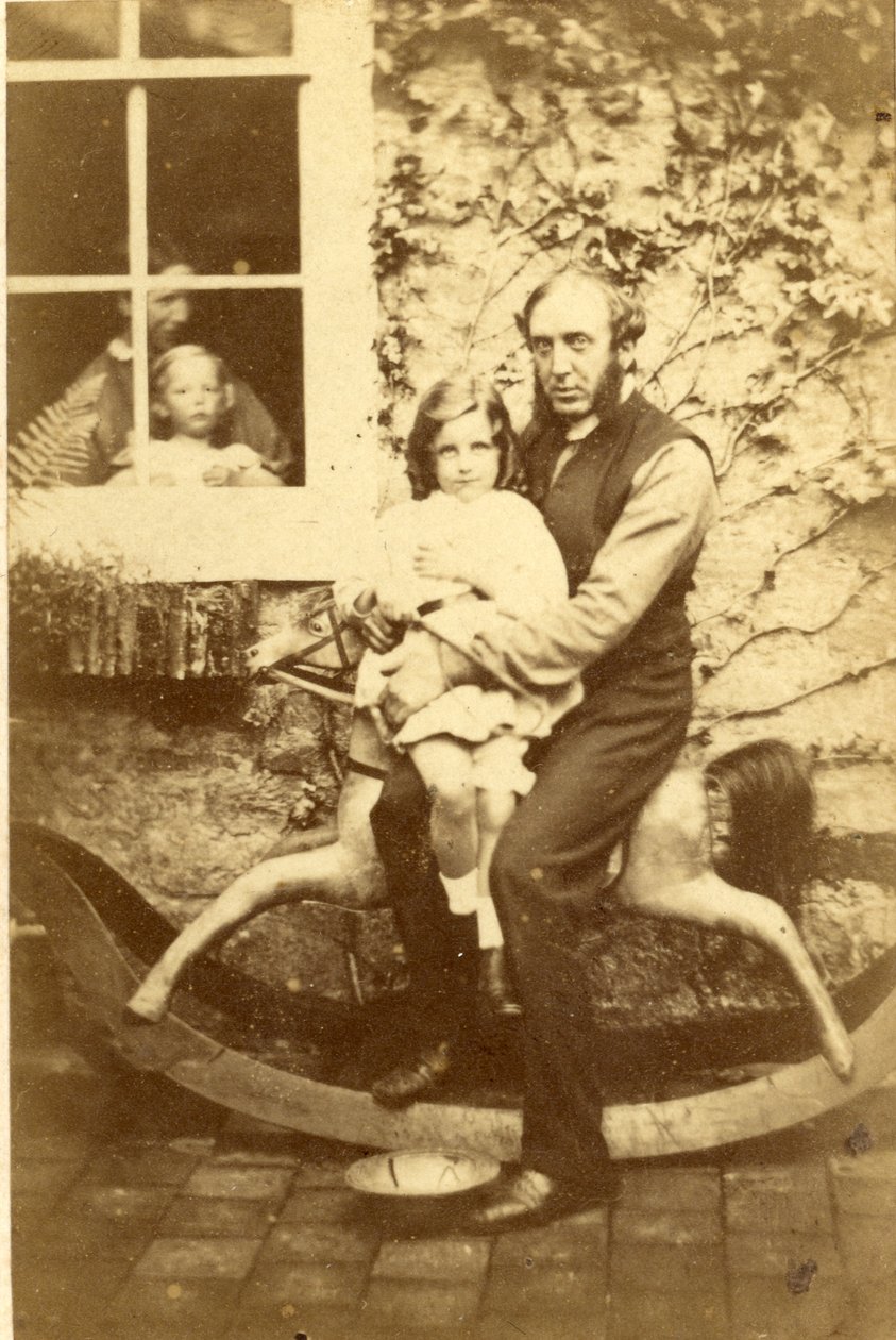 الأب وابنته يجلسان على حصان هزاز مع شقيق وأم ينظران من خلال النافذة ، 1860s (طباعة زلال) بواسطة مصور انجليزى