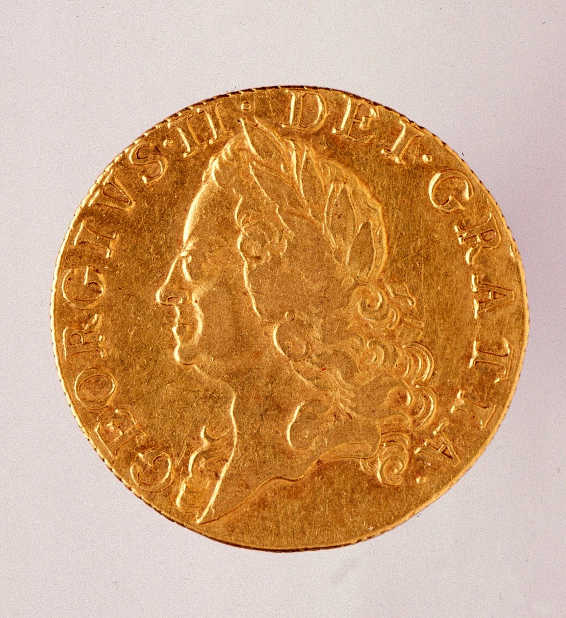 Golden english Guinea (guinee), reign of king George II (1714-1760) 18th century. Diam. 2,5 cm Naples, museo archeologico بواسطة مدرسة اللغة الإنجليزية