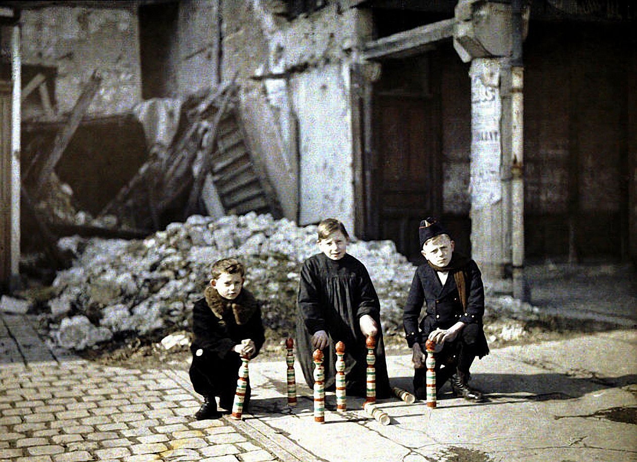 ثلاثة أطفال يلعبون بدبابيس البولينج في Place Drouet d&39;Erlon ، ريمس ، مارن ، فرنسا ، 1917 (autochrome) بواسطة فرناند كوفيل