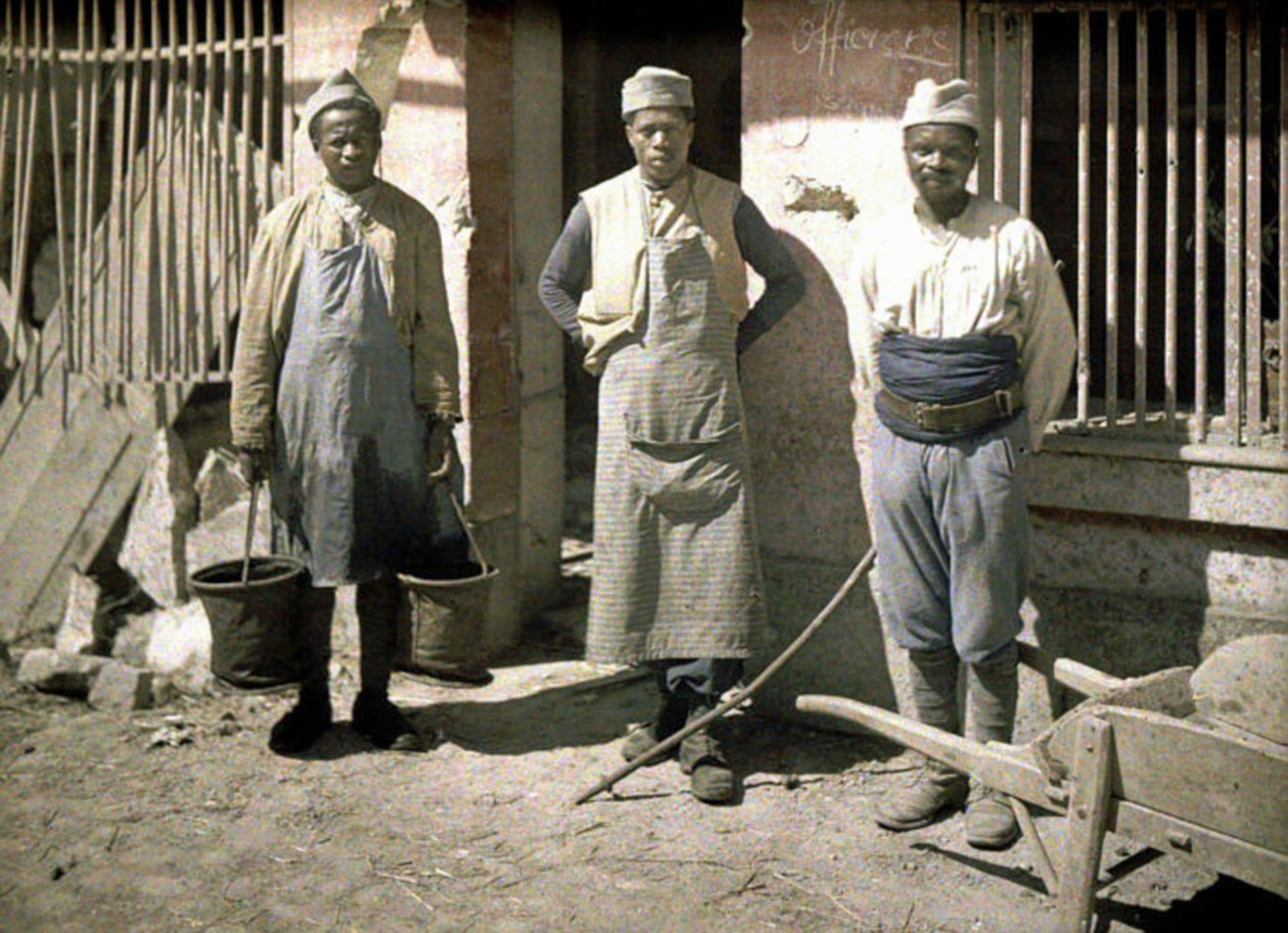 ثلاثة عمال من السنغال أمام منزل ، سواسون ، أيسن ، فرنسا ، 1917 (اللون الآلي) بواسطة فرناند كوفيل