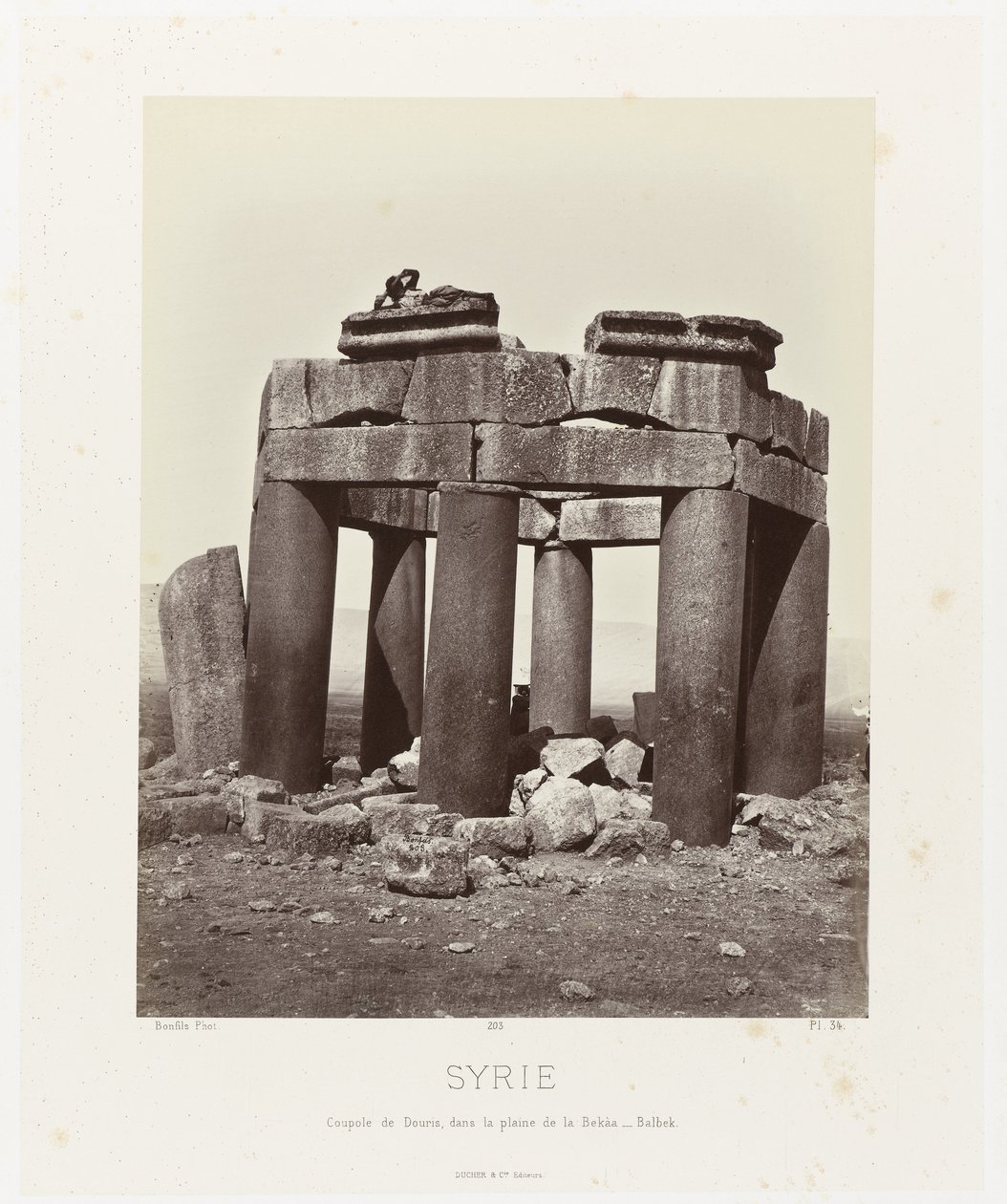 Man op by qubba van Douris، nabij Baalbek سوريا. قبة دوريس في سهل البقاع - بلبك (العنوان على وجوه) العمارة القديمة: مصر ، اليونان ، آسيا الصغرى: ألبوم صور (عنوان السلسلة) بواسطة فيليكس بونفيس