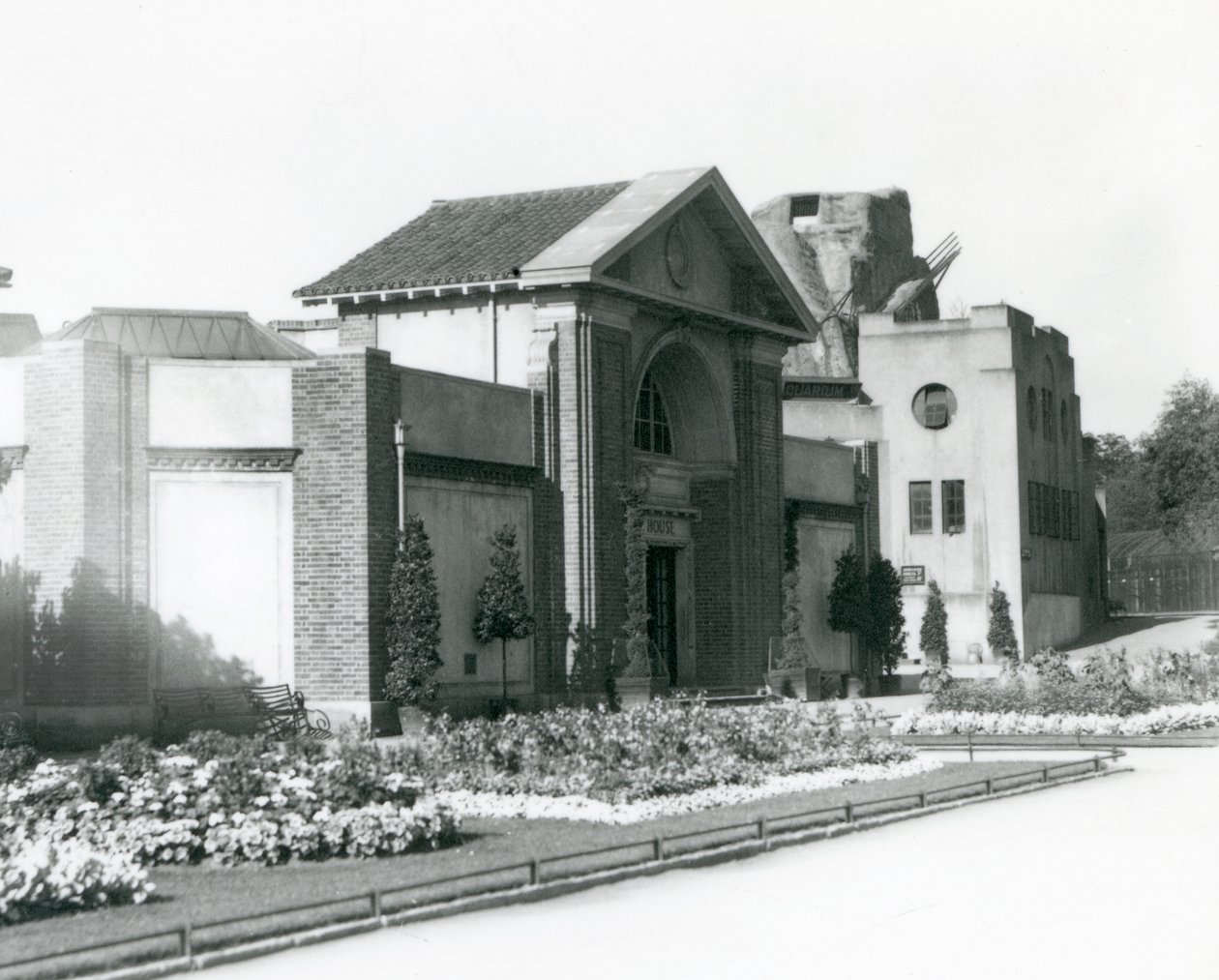 منزل الزواحف في حديقة حيوان لندن عام 1928 مع أسرة زهور رسمية على طول المسارات المؤدية إلى المدخل (صورة بالأبيض والأسود) بواسطة فريدريك وليام بوند