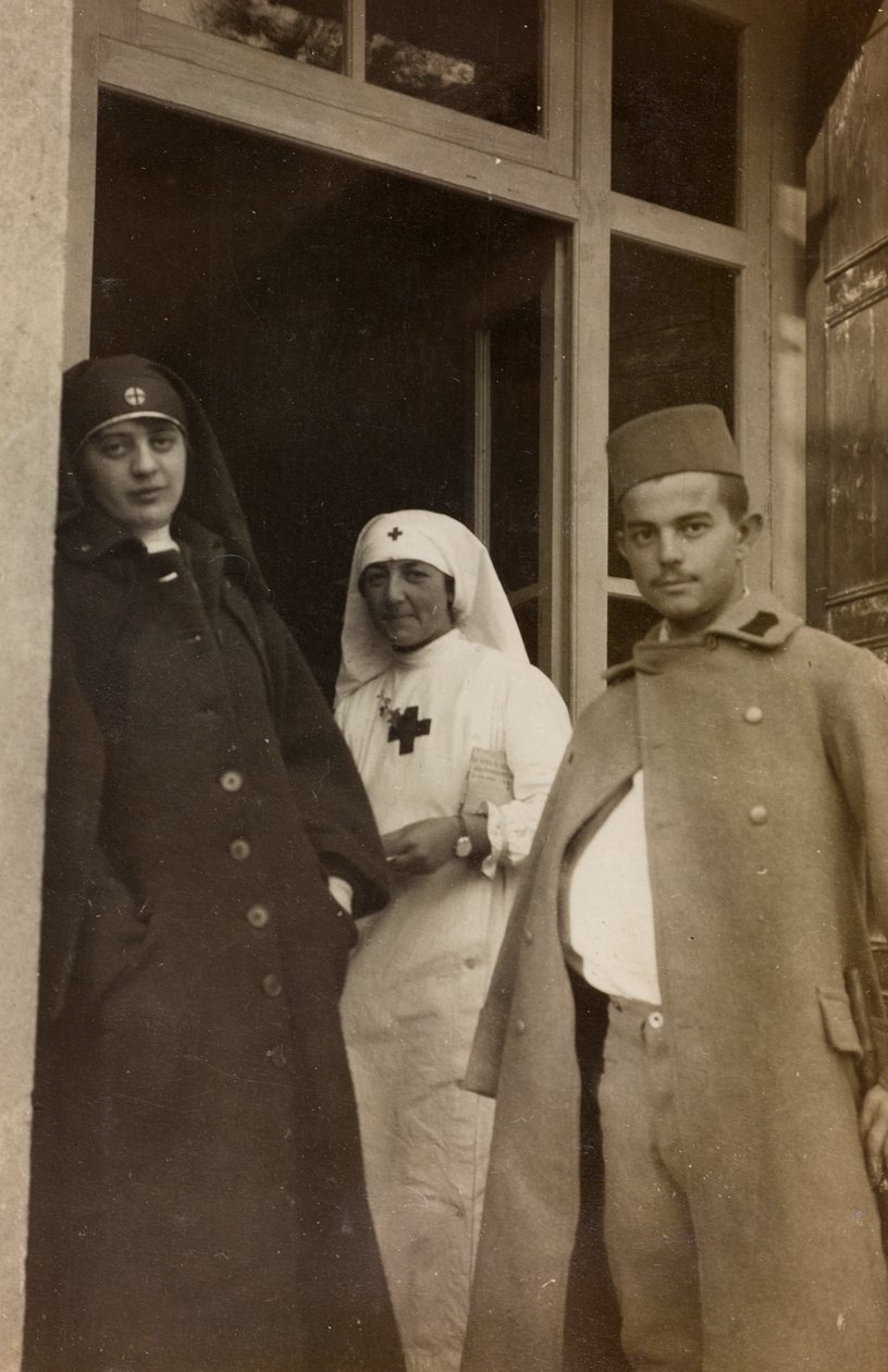 ألبوم الحرب العالمية الأولى في فريولي فينيتسيا جوليا: صورة لممرضتين من الصليب الأحمر مع طالب نمساوي متدرب في فيلا برازا ، موطن 17 من مستشفى الحرب في سوليشيانو مانزانو (صورة بالأبيض والأسود) بواسطة L. Verdiani