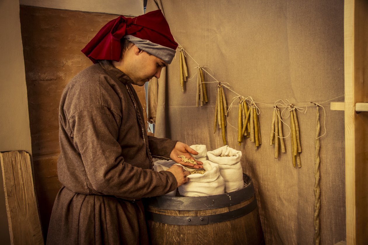 Historical reenactment: Candles and sacks of wheat, rye and barley in the apothecary of Diotaiuti, Imola, Italy, mid-14th century (photo) بواسطة غير معروف غير معروف