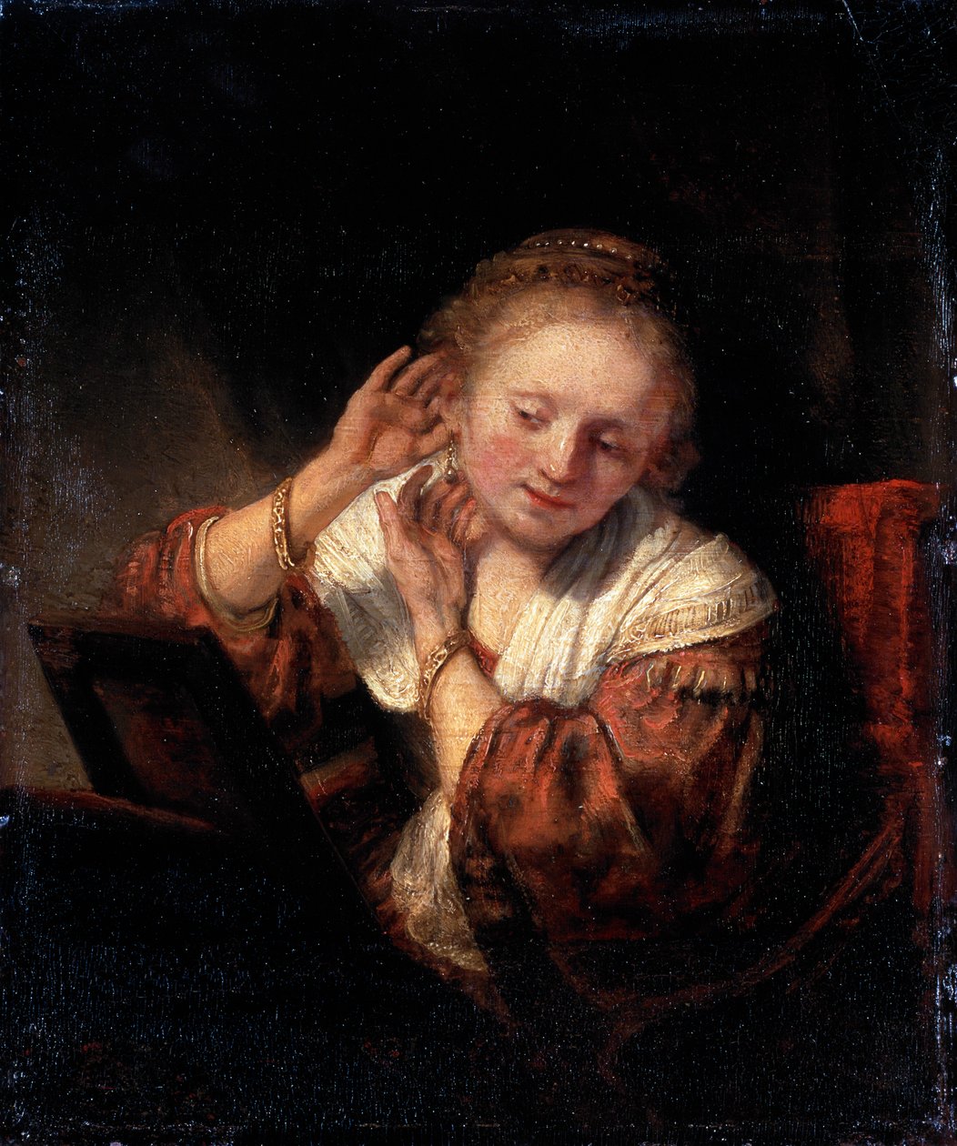 امرأة شابة تحاول الأقراط ، 1657. بواسطة رامبرانت فان راين