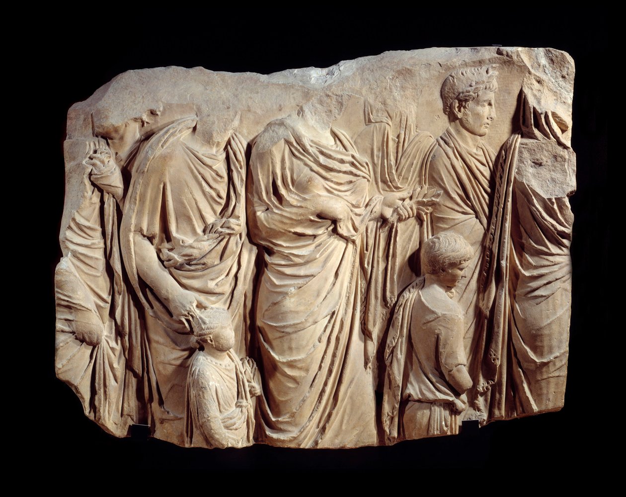 الفن الروماني: جزء من نحت معماري من الرخام من موكب Ara Pacis Augustae (مذبح السلام): موكب ، أثناء التضحية ، لشخصيات في توجا وأطفال. حوالي 13-9 ق. البحث في روما (Champ de Mars Palais Fiano) الشمس. 1،1x1،4 م بواسطة رواية
