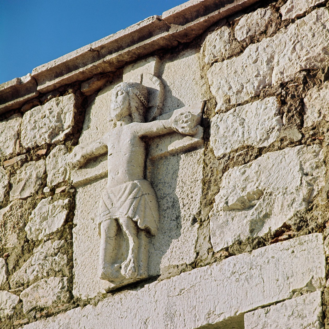 Christ crucifies Stone sculpture of the 13th century. Portal of the Romanesque Church of San Bartolomeo, Campobasso Italy بواسطة رومانيسك