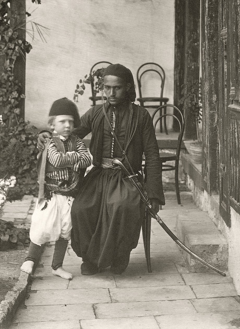 القواس العربي (الحرس العثماني) مع صبي صغير في حديقة منزل في منطقة يهودا بالقدس ، 1867 بواسطة الرقيب هنري فيليبس