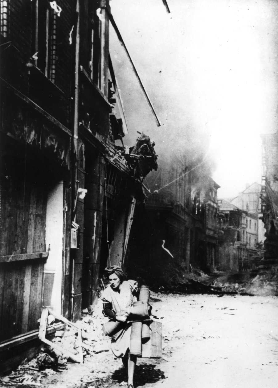 امرأة تغادر منزلها المحترق في شارع مفجر ، ألمانيا ، 1945 بواسطة غير معروف