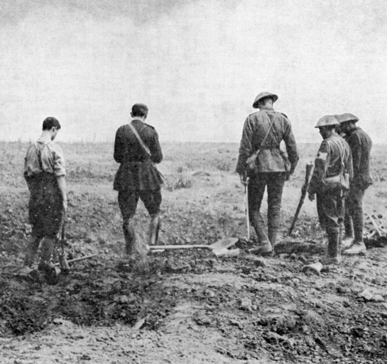 قسيس يقوم بخدمة الدفن في الميدان بينما يدفن حزب الدفن احترامه ، c1916 بواسطة غير معروف