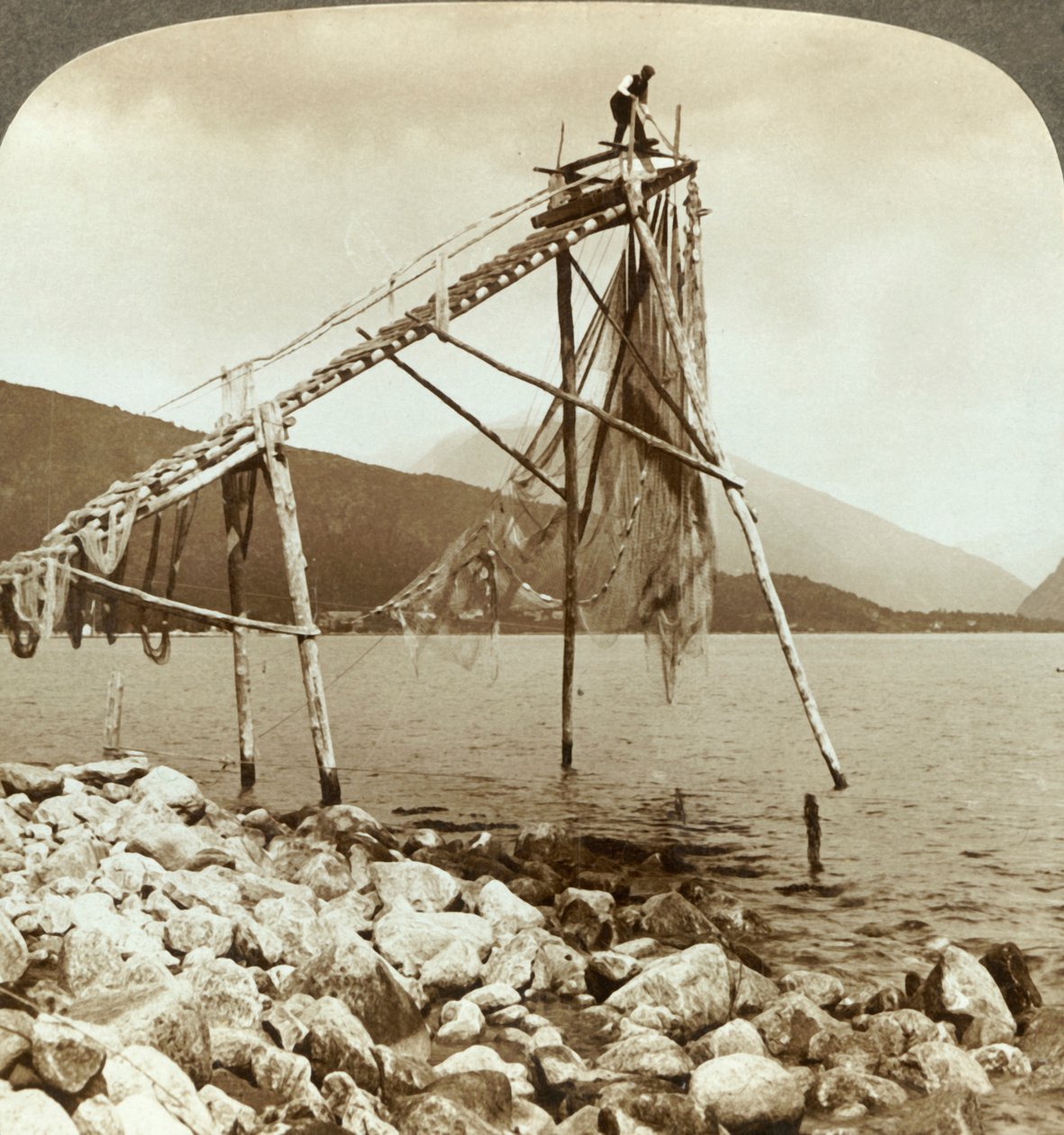 صياد ترتيب شباك السلمون في Balestrand على Sognefjord - Balholm في المسافة ، النرويج ، c1905. بواسطة غير معروف