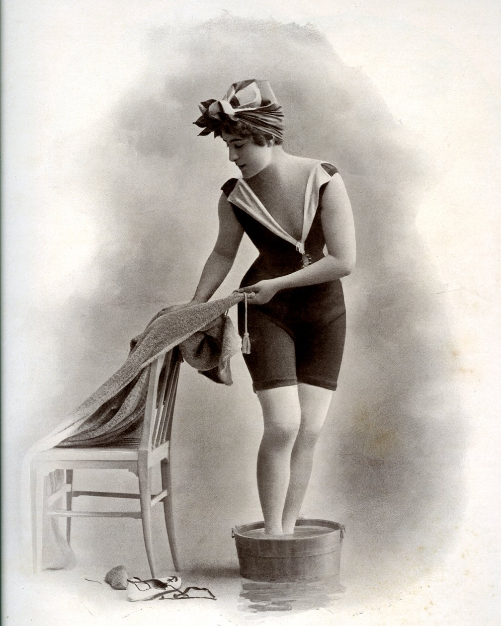 امرأة شابة في ملابس السباحة (من Belle Epoque) تأخذ حمامًا للقدم ، حوالي عام 1900 (صورة b / w) بواسطة فنان غير معروف