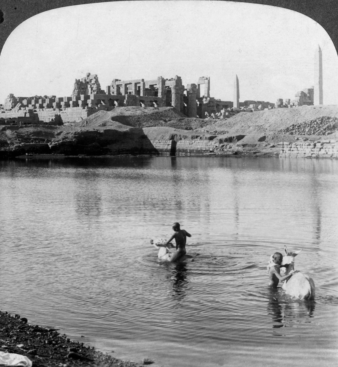 النظر عبر البحيرة المقدسة إلى المعبد الكبير في الكرنك ، طيبة ، مصر ، 1905. بواسطة أندروود أند أندروود