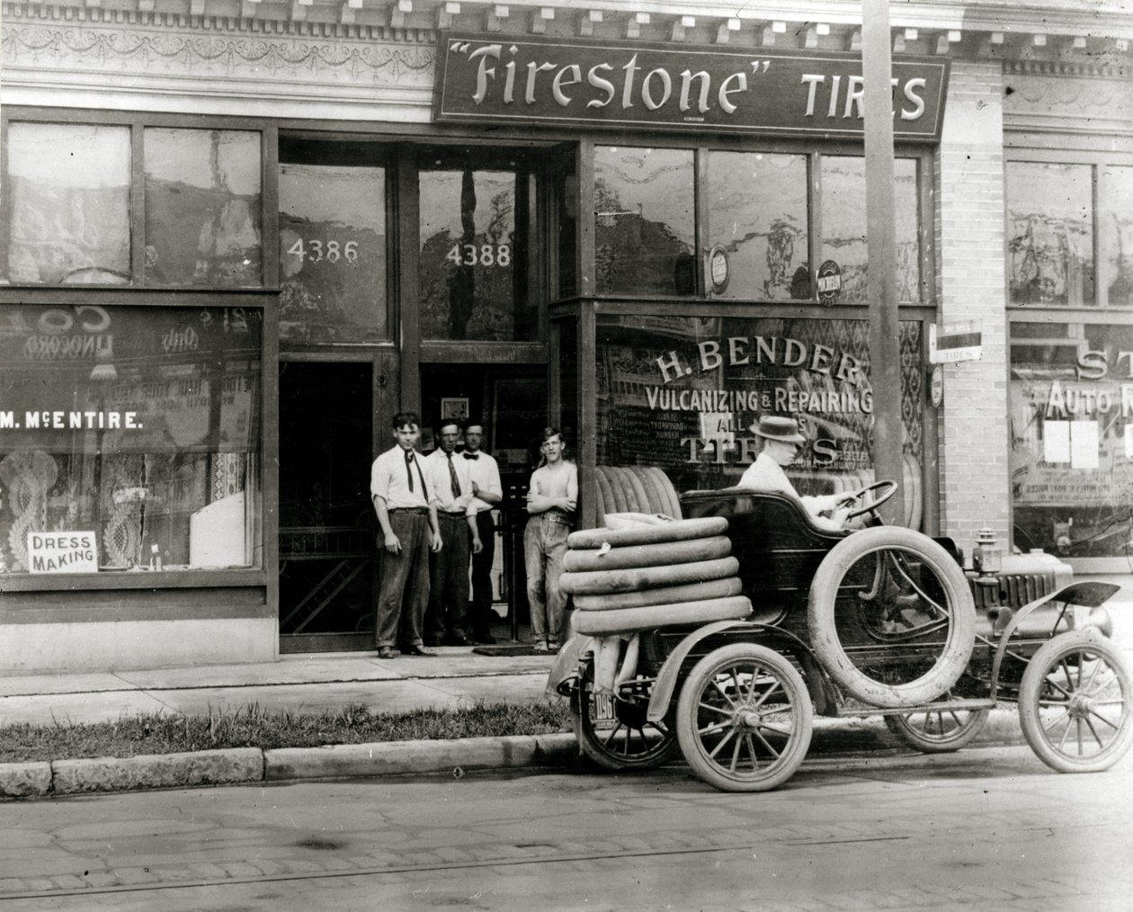 تجمع الرجال وشاحنة إصلاح إطارات السيارات خارج وكالة H. Bender Firestone Tyre في 4388 شارع الزيتون بواسطة غير معروف