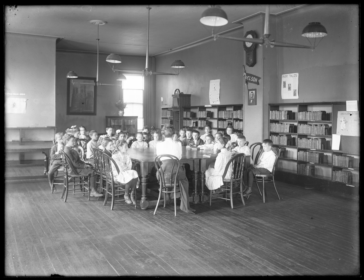 أطفال يستمعون إلى امرأة في غرفة القراءة في فرع مجهول من مكتبة Queens Borough العامة ، ج .1910 بواسطة وليام ديفيس هاسلر