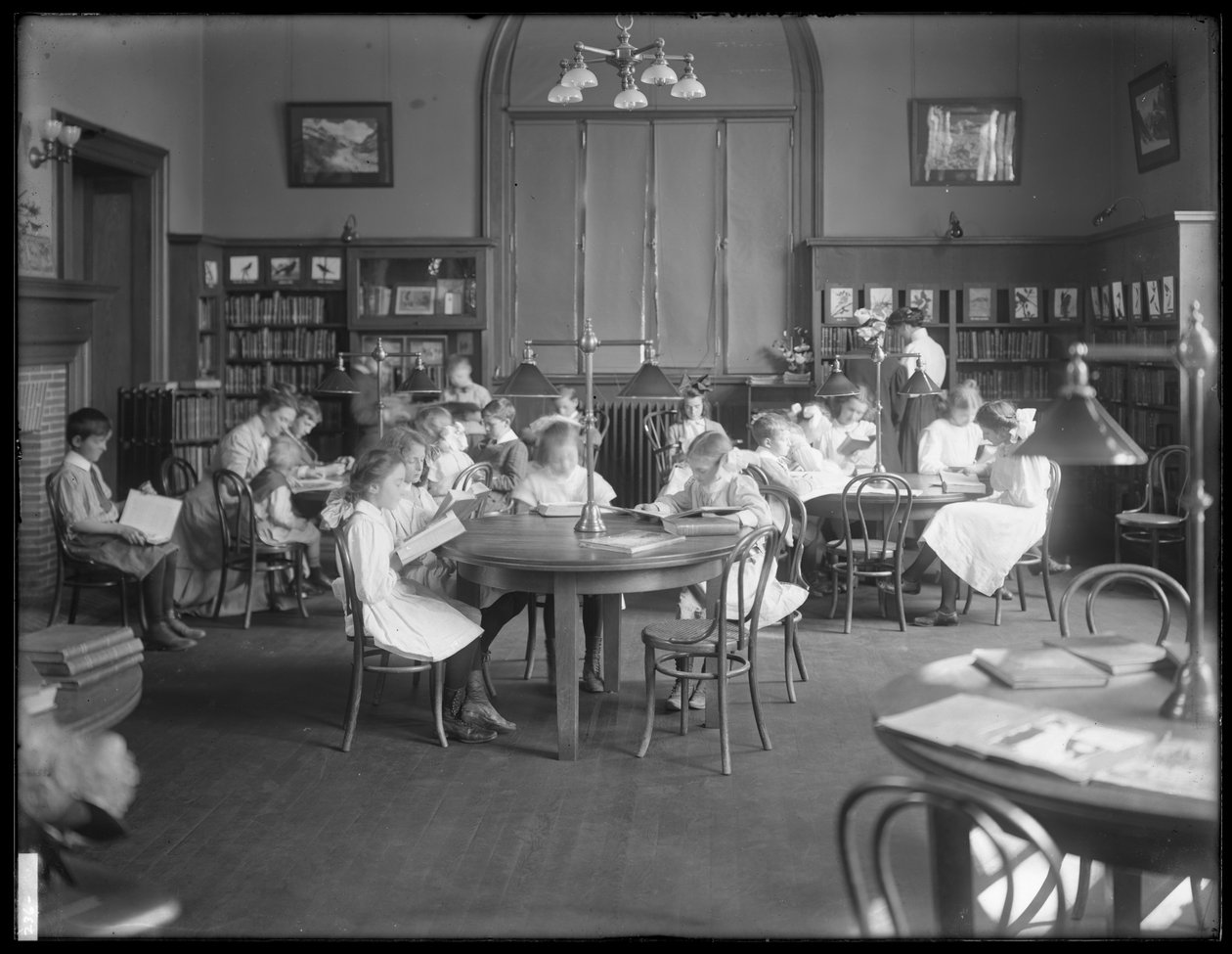 أطفال يقرؤون في غرفة القراءة في فرع مجهول من مكتبة Queens Borough العامة ، ج .1910 بواسطة وليام ديفيس هاسلر