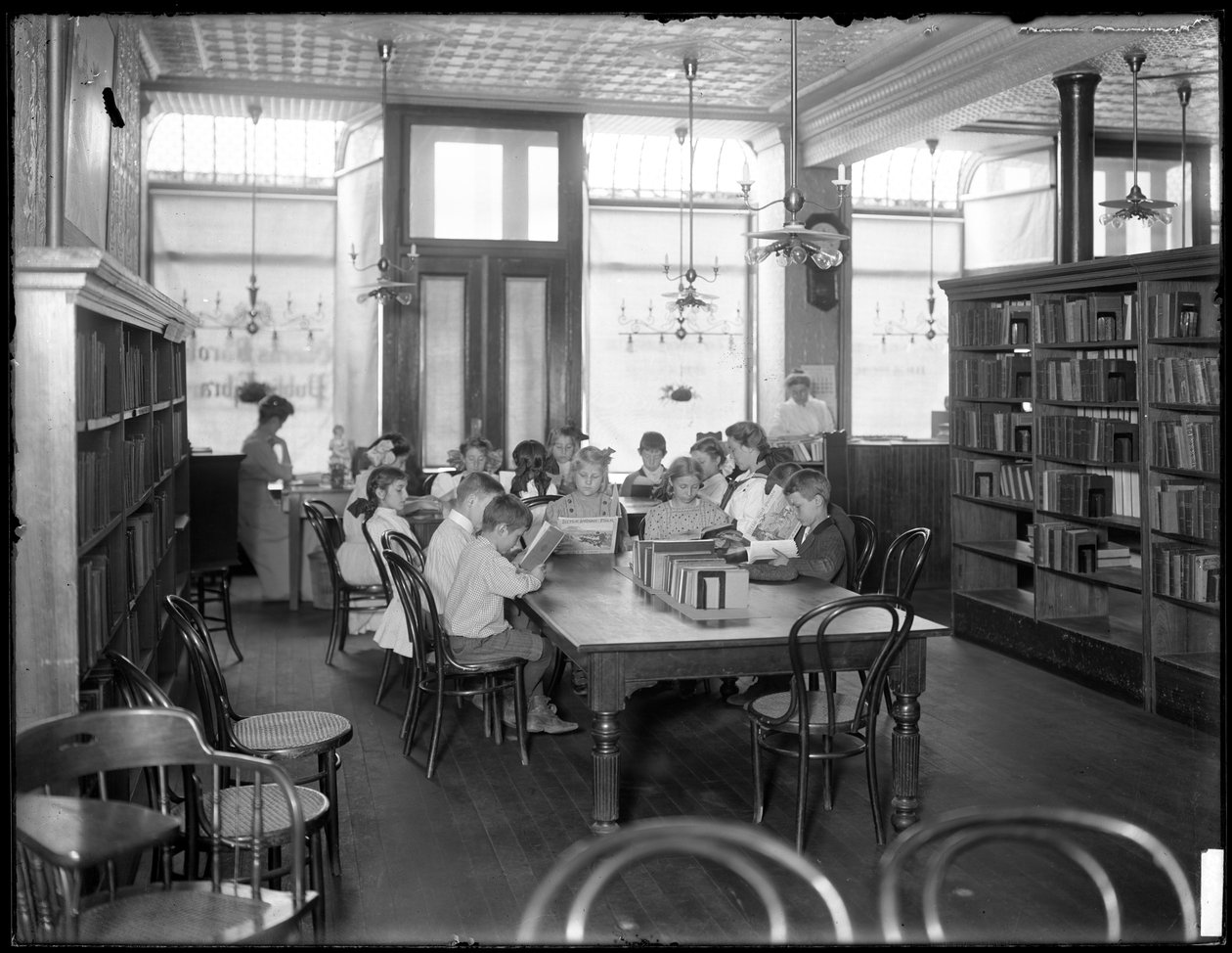 أطفال يقرؤون في غرفة القراءة في فرع مجهول من مكتبة Queens Borough العامة ، ج .1910 بواسطة وليام ديفيس هاسلر