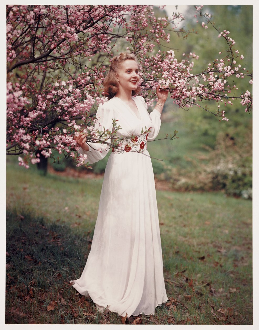 Woman modelling a dress near blossom, c 1940s بواسطة فريدريك (المرتبط ب) بارنارد