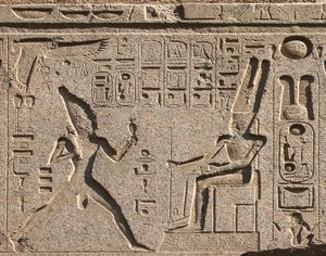 قطعة أثرية مصرية: تزين تفاصيل العمارة تمثيل الفرعون رمسيس الثاني تكريماً للإله آمون والكتابات الهيروغليفية ، معبد الفرعون رمسيس الثاني (1292-1186 قبل الميلاد) في الأقصر. الضفة الشرقية (طيبة) ، مصر بواسطة الأسرة المصرية التاسعة عشرة