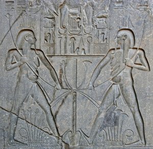 الآثار المصرية: تفاصيل قاعدة تمثال الفرعون رمسيس الثاني (1292-1186 قبل الميلاد) التي تمثل اتحاد مصر العليا والسفلى. معبد الأقصر. الضفة الشرقية (طيبة) ، مصر بواسطة الأسرة المصرية التاسعة عشرة