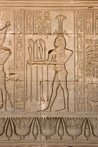 الأثريون المصريون: تمثيل لإله النيل وحابي والهيروغليفية ، معبد حتحور ، دندرة ، مصر - الحضارة المصرية: إله النيل وحابي والكتابات الهيروغليفية المنحوتة على جدار معبد حتحور (أو معبد تينتيرا) في دندرة بواسطة الفترة البطلمية المصرية