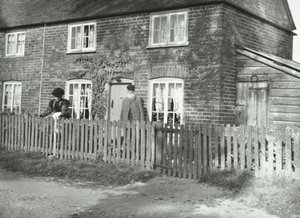 مشهد ريفي في منطقة Wandsworth مع زوجين مسنين في حديقة عقار على طراز الكوخ ، لندن ، 1895 بواسطة مصور انجليزى