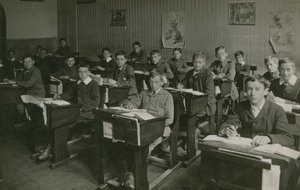 التلاميذ الذكور يجلسون خلف مكاتبهم خلال درس في المدرسة بواسطة مصور انجليزى