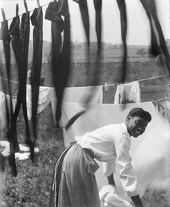 امرأة أمريكية إفريقية شابة تعلق الغسيل لتجف في نيوبورت ، رود آيلاند ، c.1902 (صورة b / w)