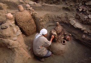 ريتشارد غوميز ينظف القطع الأثرية المكتشفة حديثاً في موقع الحفر بالمدرسة، 2001 (صورة) بواسطة ايرا بلوك