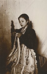 امرأة شابة تقوم بالخياطة، توسكانا، إيطاليا، حوالي عام 1910 بواسطة مصور إيطالي