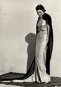 نموذج في فستان السهرة من تصميم دار الأزياء الإيطالية "دراغوني". يكمل المقال عباءة طويلة من المخمل (صورة b / w) بواسطة لويس بوجينو