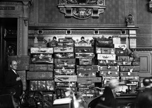 محاكمة الطبيب مارسيل بيتيو (قاتل متسلسل) مارس 1946: مارسيل بيتيو في قفص الاتهام، في الخلفية: الحقائب والصناديق التي وضع فيها الأشياء الثمينة التي سرقها من ضحاياه) بواسطة رينيه سانت بول