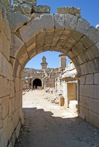 منظر من خلال المدخل المقبب لمسرح Xanthos في حفرة الأوركسترا ، يُظهر العمود وقبر Harpy ، Xanthos ، تركيا (صورة) بواسطة رواية