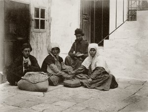 امرأة تطحن الدقيق بأحجار طاحونة مستديرة داخل فناء منزل في القدس ، 1867