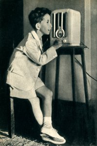الملك فيصل ملك العراق يستمع إلى بث أعدته بي بي سي في عيد ميلاده عام 1942. بواسطة غير معروف