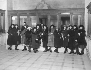 الولايات المتحدة: حوالي عام 1926 مجموعة من النساء يقفن عند نوافذ صراف التوفير في أحد البنوك. (ب / ث الصورة) بواسطة غير معروف
