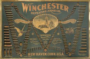 لوحة عرض خرطوشة Winchester ، مع مجموعة شاملة من البنادق المعدنية والنحاسية والورقية وخراطيش الطلقات مرتبة في شكل "W" ممتد بواسطة غير معروف